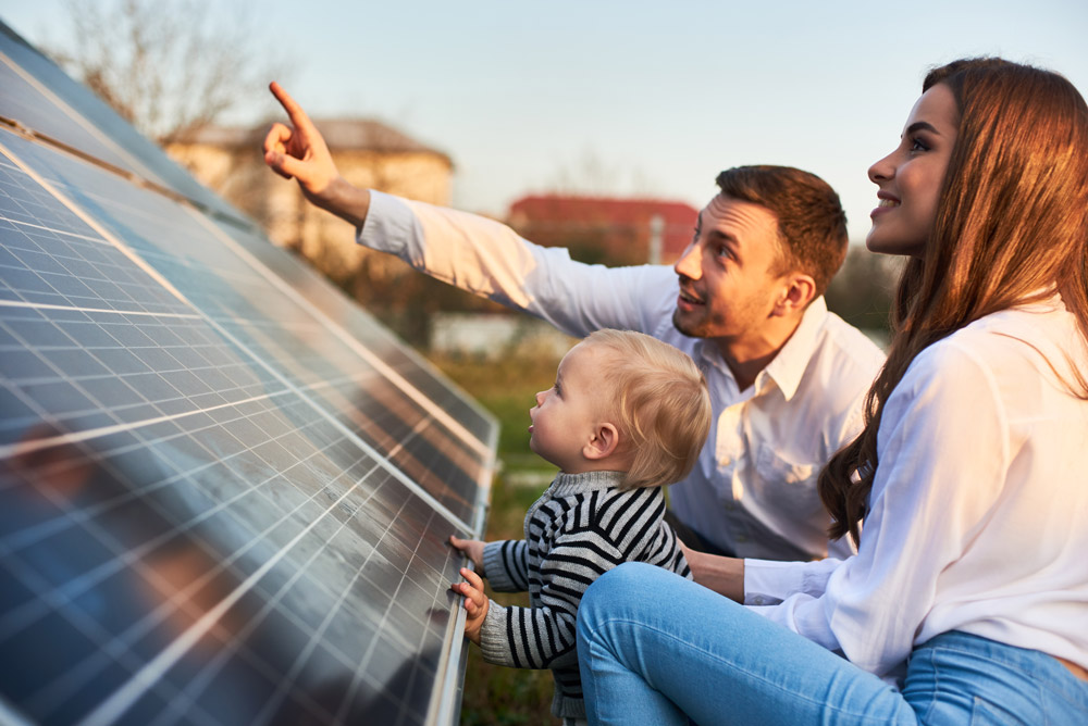 Three people admiring a solar panel